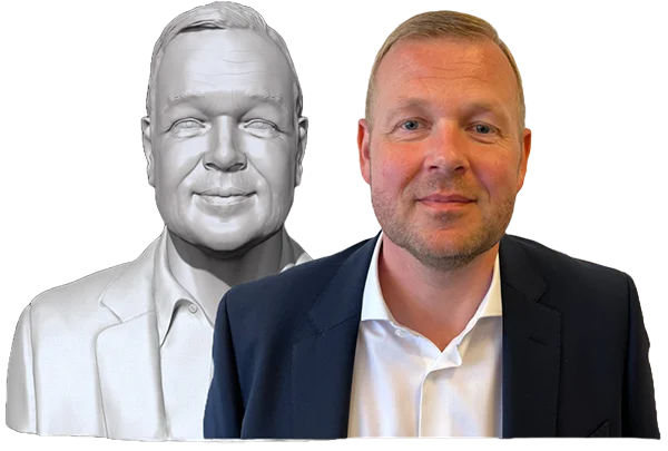 Et billede af en mand i en mørk blazer og hvid skjorte ved siden af en digital 3D-scannet buste af sig selv